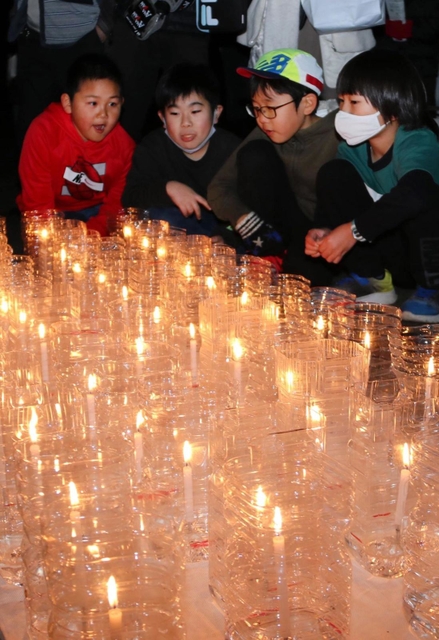 ６年ぶりの追悼式で、尼崎市内で亡くなった４９人を悼むろうそくを見つめる子どもたち＝尼崎市東七松町１