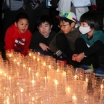 ６年ぶりの追悼式で、尼崎市内で亡くなった４９人を悼むろうそくを見つめる子どもたち＝尼崎市東七松町１
