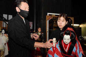 舞台裏での人形遣いの練習風景。全体練習はほとんどなく、演目の合間を縫ってベテランに教えを請い腕を磨く＝南あわじ市福良甲