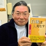 新たに出版された「白球は死なず」を手にする大鐘稔彦さん＝南あわじ市阿那賀