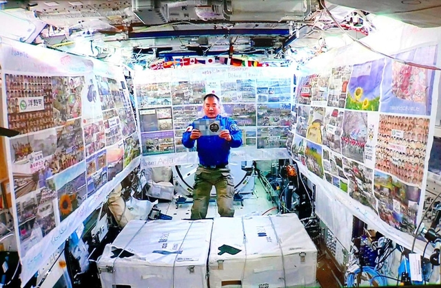 横断幕を張った実験棟「きぼう」で東北の言葉を読み上げる宇宙飛行士の野口聡一さん