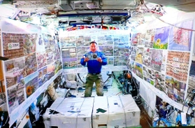横断幕を張った実験棟「きぼう」で東北の言葉を読み上げる宇宙飛行士の野口聡一さん