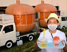 タマネギ形がよく分かるキッチンカーの裏側で、商品のかき氷を持つ従業員＝南あわじ市福良丙