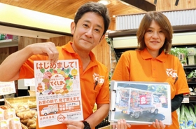 マイ・マートの店舗で、移動スーパー「とくし丸」のチラシを持つ野崎敏郎さんと裕子さん夫婦＝淡路市中田