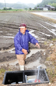 「自然圧パイプライン」のバルブをひねり、水が入る田んぼ＝洲本市五色町都志大宮