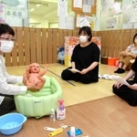妊婦らに赤ちゃんのお風呂の入れ方を指導する浜田チヨ子さん（左）＝ファミリーサポートセンターまあるく