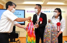 津名高校の仲山惠博校長（左）から１万羽の折り鶴を贈られる坂東悠汰選手の父和紀さんと母麻美さん＝津名高校