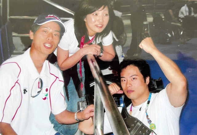 アテネパラリンピックの試合後、現地で写真におさまる（右から）宇城元選手、妻美津穂さん、弟の大さん（芳子さん提供）