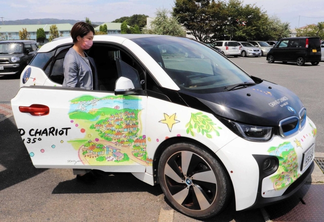 パソナグループの宿泊施設の案内がラッピングされたＢＭＷの社用車＝淡路市久留麻