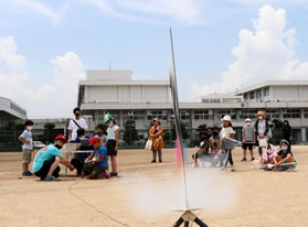 参加した子供らを前に、煙を上げて飛び立つロケット＝洲本高校