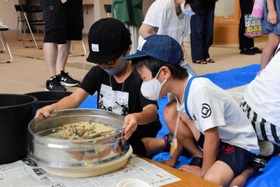 浜辺の砂をふるいにかけごみを選別する児童ら＝淡路市浦