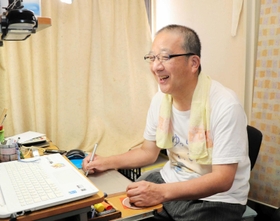 パソコンを使い、イラストを完成させるちでまるさん＝淡路市