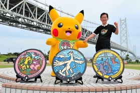 ３枚の「ポケふた」を前に、ピカチュウと並ぶ門康彦淡路市長＝道の駅あわじ