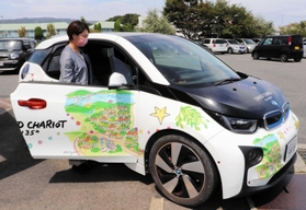 パソナグループの宿泊施設の案内がラッピングされたＢＭＷの社用車＝淡路市久留麻