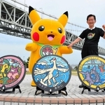 ３枚の「ポケふた」を前に、ピカチュウと並ぶ門康彦淡路市長＝道の駅あわじ
