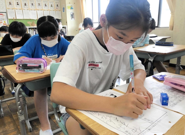 マスク姿で２学期の目標を書く児童＝洲本第二小学校