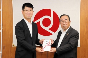聖智学園の三浦一広施設長（左）に寄付の目録を手渡す淡陽信用組合の山本英博理事長＝洲本市栄町１、淡陽信用組合本店