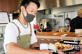 出来上がった定食を客に届ける「淡路島食堂まるわ」の山本輝明さん＝淡路市岩屋、淡路シェフガーデン