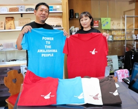 完成したＴシャツを持つ木村昭義さんと和美さん＝洲本市宇原