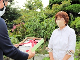 国土交通大臣表彰の記念盾を受け取る、「堺活性化委員会花かんざし」の浜田満子代表（右）＝洲本市五色町下堺