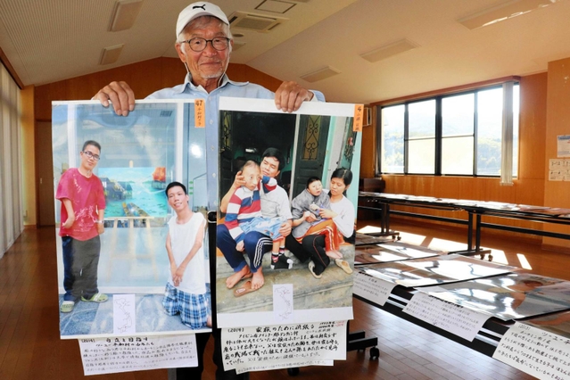 現地で自ら撮影した写真を持つ西村さん＝洲本市