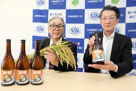 完成した清酒を持つ久田浩嗣社長（右）と、原料米の稲穂を持つ相野公孝農学部長＝南あわじ市志知佐礼尾