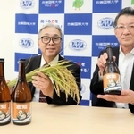 完成した清酒を持つ久田浩嗣社長（右）と、原料米の稲穂を持つ相野公孝農学部長＝南あわじ市志知佐礼尾