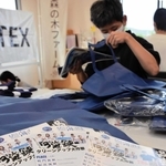 ３海峡クリーンアップ大作戦の参加者に配るグッズを詰める森の木ファームの通所者＝南あわじ市賀集八幡