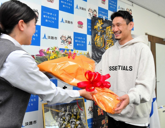 女性職員から花束を贈られる住村竜市朗選手＝淡路市役所