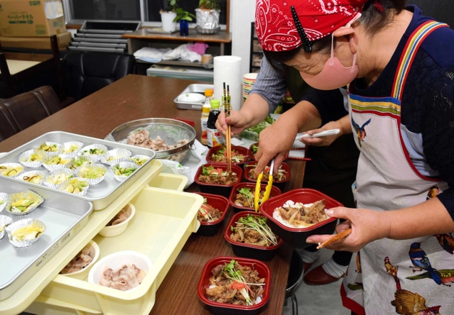 猪肉のメニューを盛り付ける伊加利地区の主婦ら＝伊加利地区公民館