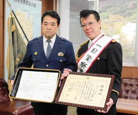 一日警察署長を務めた秋山さん（右）と藤田恒署長＝洲本署