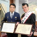 一日警察署長を務めた秋山さん（右）と藤田恒署長＝洲本署