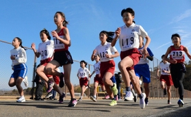 新春の青空を背に駆け出す小学６年女子の選手ら＝アスパ五色