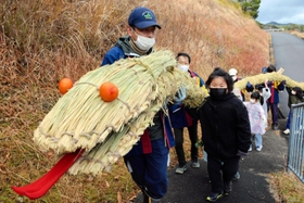 わらで作った大蛇を担ぐ地域住民ら＝南あわじ市倭文安住寺