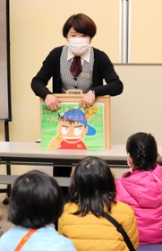 淡路市立釜口保育所の園児らに震災の紙芝居を読み聞かせる上佳代美さん＝１２日、北淡震災記念公園