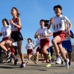 新春の青空を背に駆け出す小学６年女子の選手ら＝アスパ五色