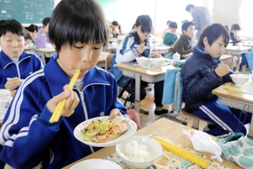 宮城県南三陸町産の銀サケを食べる児童ら＝賀集小学校