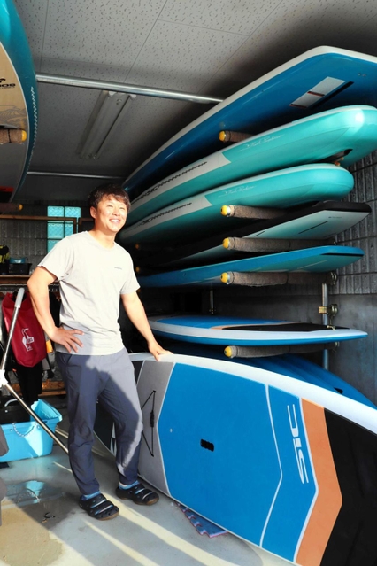 体験用のＳＵＰボードとオーナーの原田京典さん＝南あわじ市松帆古津路、慶野松原