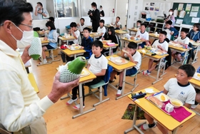 学校給食で青パパイアを味わった児童に話をする森久則さん＝２０２１年１０月、津名東小学校