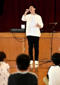 澄んだ歌声を披露する林部智史さん＝都志小学校