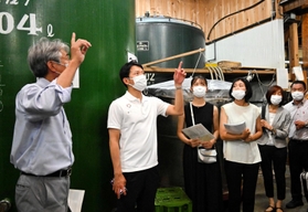 インターンシップの大学生らと酒蔵を視察する斎藤元彦知事＝千年一酒造