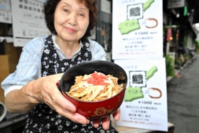 淡路島の旬の味覚を詰め込んだ「鱧そぼろ丼」と野口純子さん＝洲本市本町、レトロこみち
