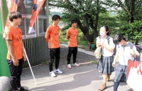 蒼開中高前であいさつ運動するＦＣ．ＡＷＪの選手＝洲本市下加茂１