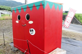 裏側に顔のデザインがある真っ赤な無人販売所＝淡路市尾崎