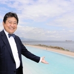 目玉の水着で入る温泉を指すアクアイグニス淡路島の古市尚社長＝淡路市夢舞台