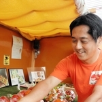無人販売所の中にトマトを並べる田中孝樹さん＝淡路市尾崎