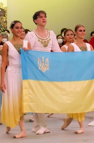 イワノワさん（左）とシュリヒテルさん（右）が、共演したダンサーと共にウクライナ国旗を掲げた＝淡路市野島大川