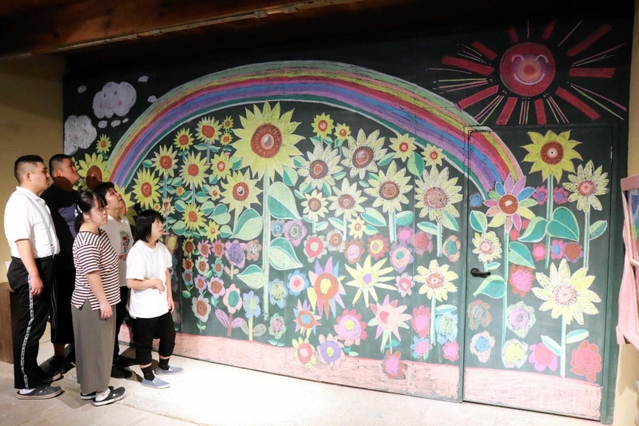 壁一面の黒板に描いたヒマワリと利用者＝洲本市本町７