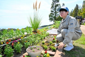 秋らしい草花を集めた庭づくりに取り組む淡路高校の原明日美さん＝あわじ花さじき