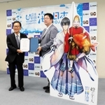 江埼灯台を擬人化したキャラクターパネルを前に贈呈書を手渡す柴田英知さん（右）と門康彦市長＝淡路市生穂新島